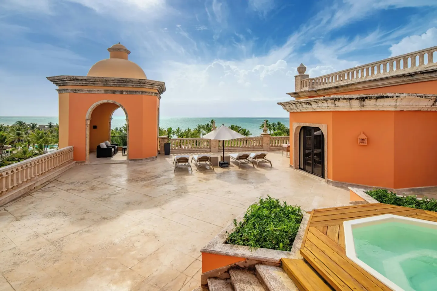 Oceanfront terrace with loungers, orange architecture, and plunge pool at Sanctuary Cap Cana, a Luxury Collection Resort.