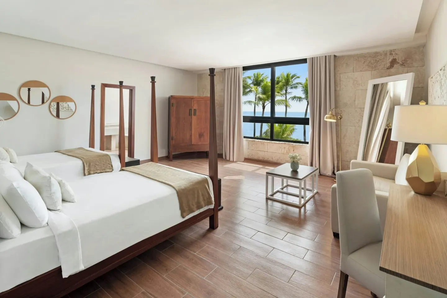 Spacious guest room with king bed and palm-lined ocean view at Sanctuary Cap Cana, a Luxury Collection Resort.