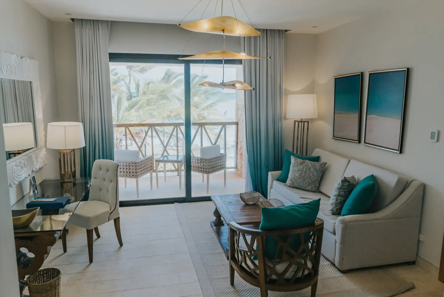 Suite sitting area with balcony and palm views at Sanctuary Cap Cana, a Luxury Collection Resort.