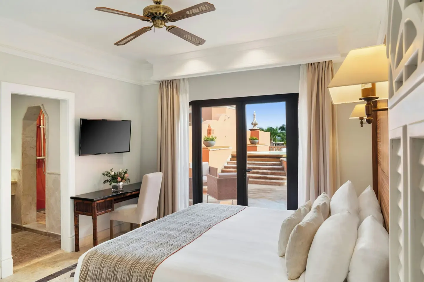 Guest room with king bed, wall-mounted TV, and terrace access at Sanctuary Cap Cana, a Luxury Collection Resort.