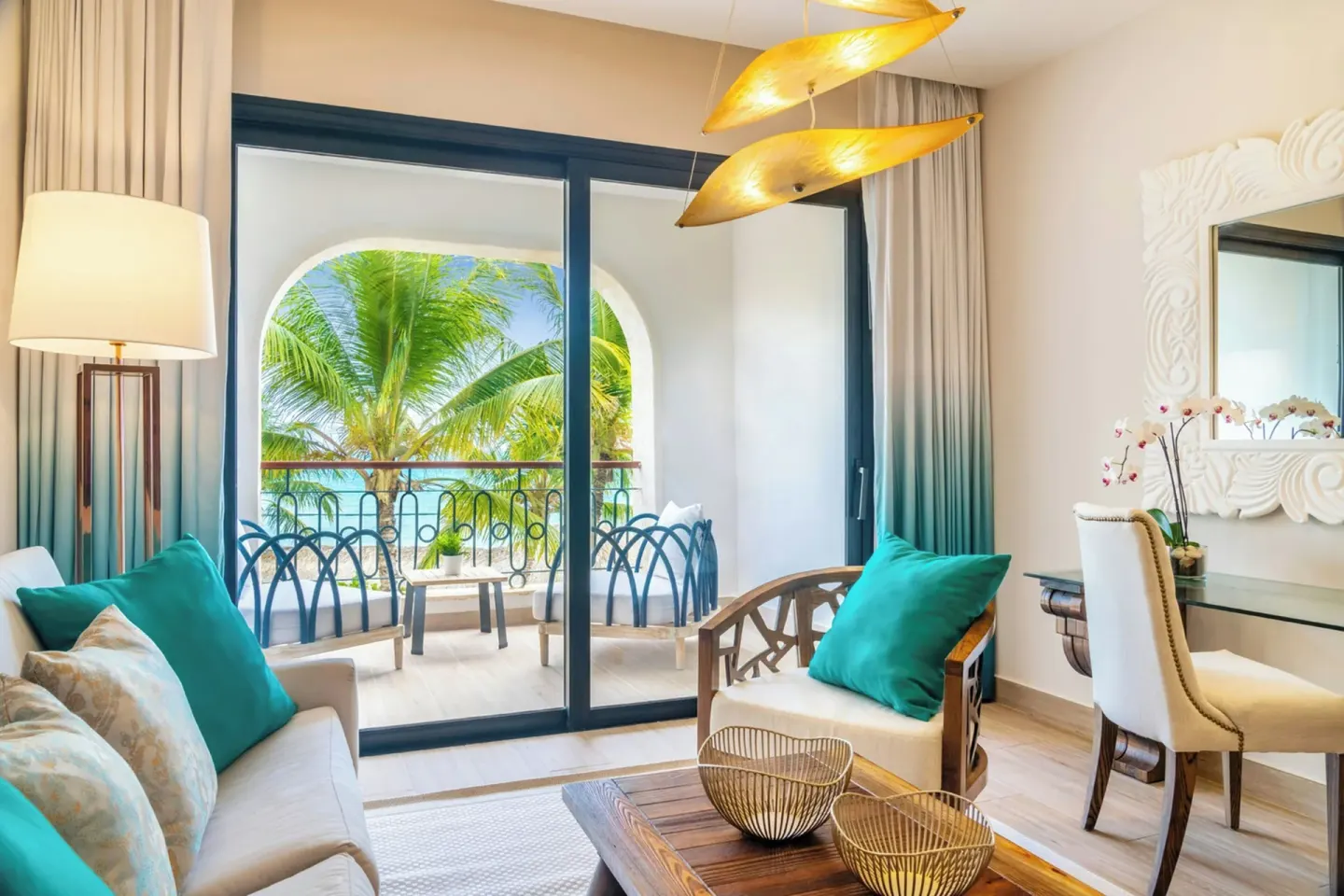 Junior Room lounge with sliding doors to a furnished balcony at Sanctuary Cap Cana, a Luxury Collection Resort.