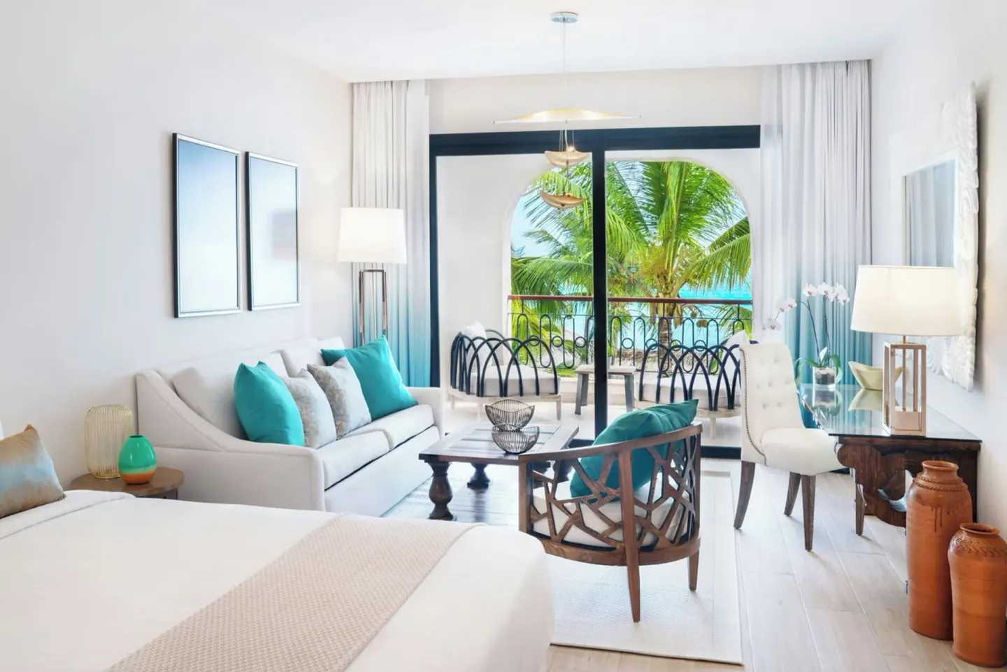 Junior Room sitting area with balcony, sofa, desk, and palm view at Sanctuary Cap Cana, a Luxury Collection Resort.