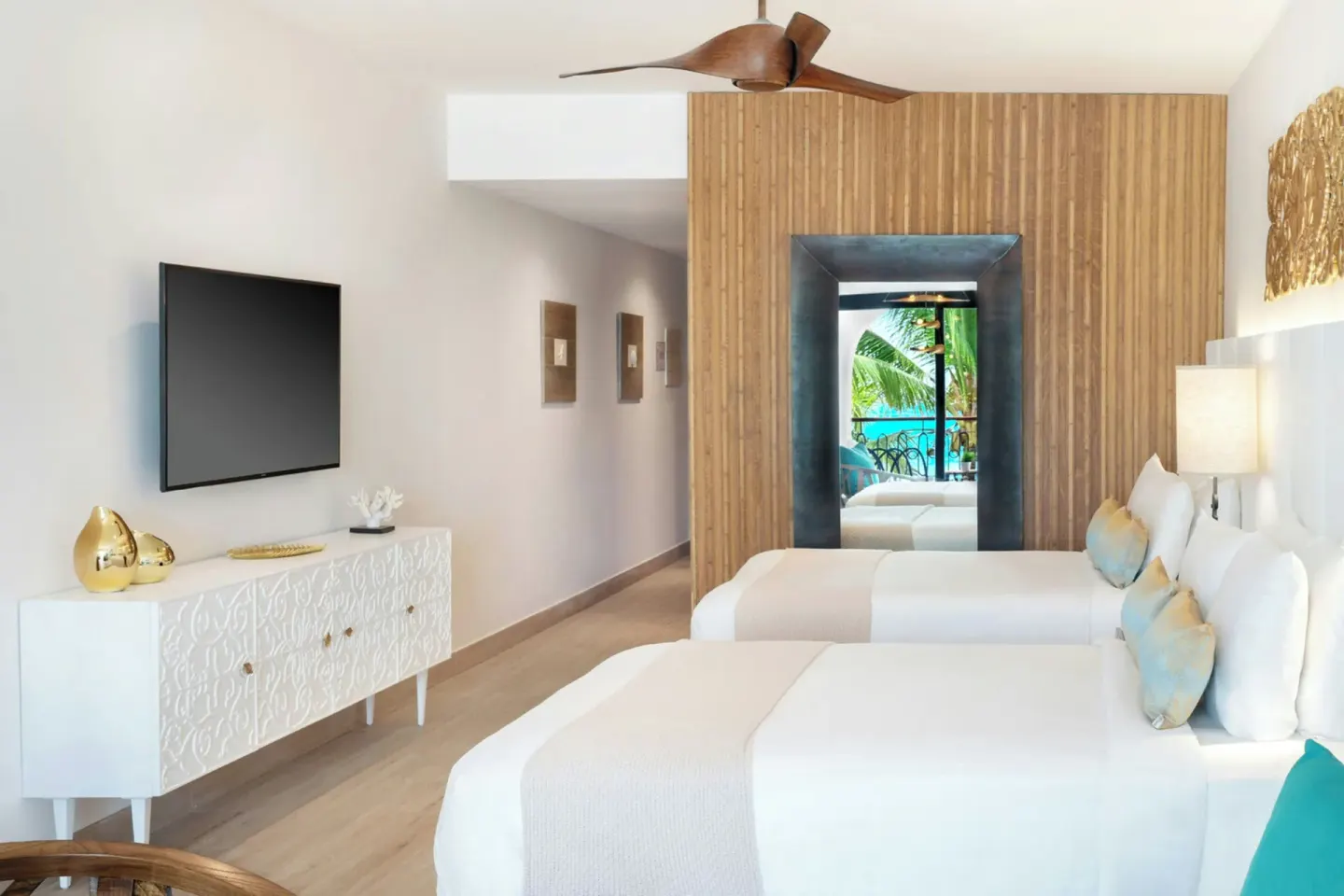 Junior Room with two beds, TV console, and balcony reflected in mirror at Sanctuary Cap Cana, a Luxury Collection Resort.