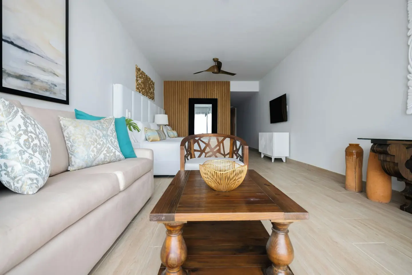Junior Room seating area with sofa, coffee table, and beds beyond at Sanctuary Cap Cana, a Luxury Collection Resort.