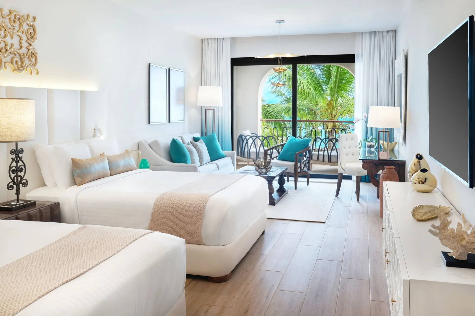 Junior Room with two beds, seating area, balcony, and palm view at Sanctuary Cap Cana, a Luxury Collection Resort.