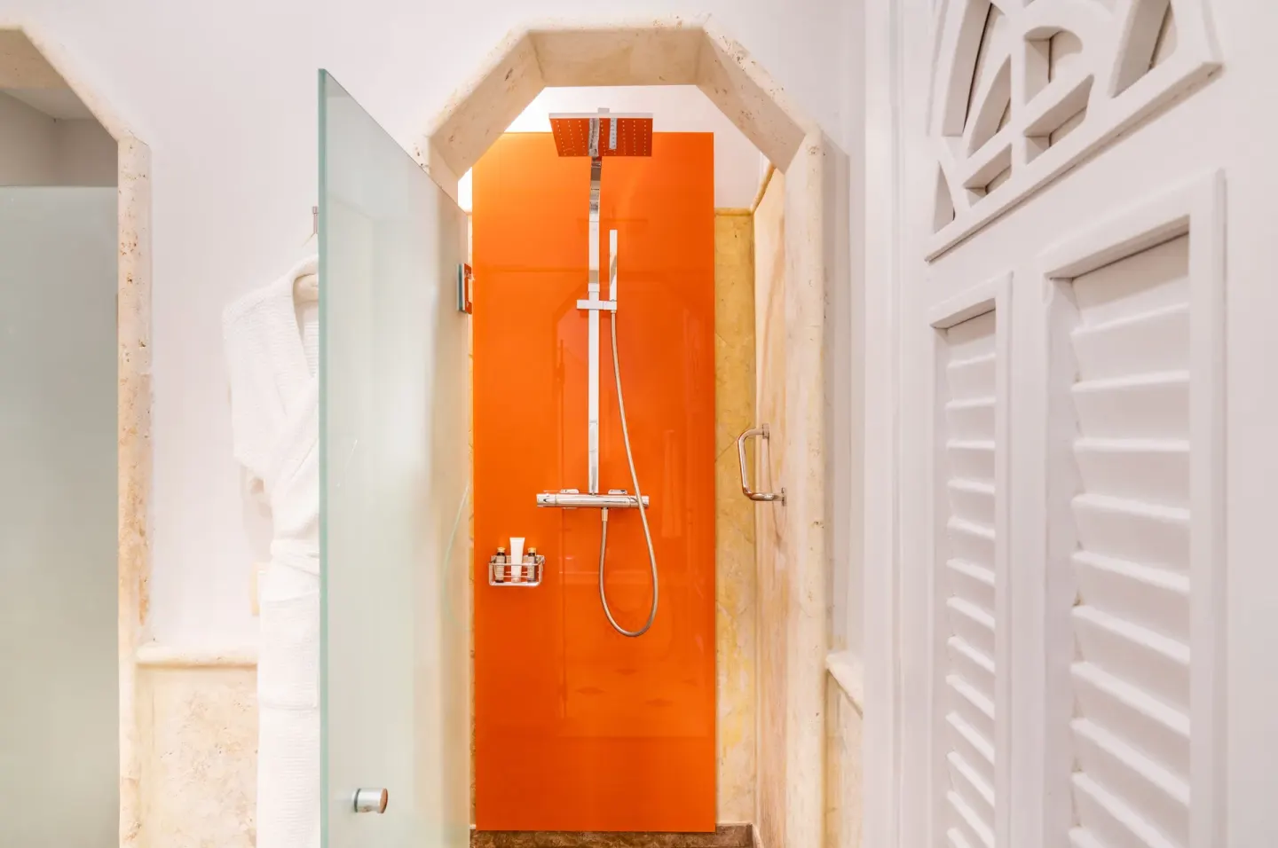 Junior Suite shower with orange accent wall at Sanctuary Cap Cana, a Luxury Collection Resort.