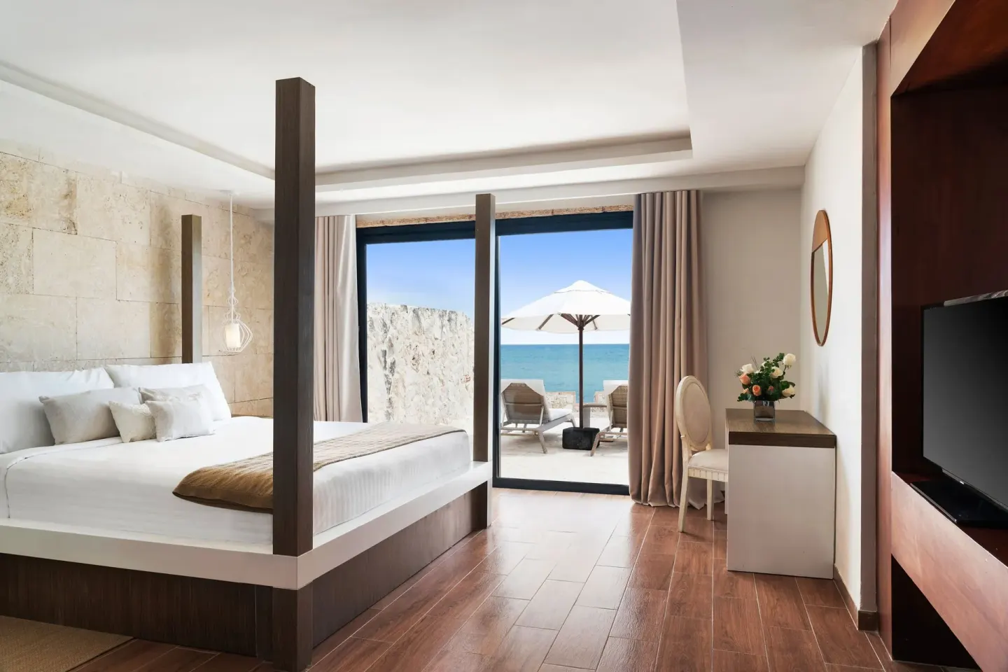 Four-poster king bed with terrace and ocean view at Sanctuary Cap Cana, a Luxury Collection Resort.