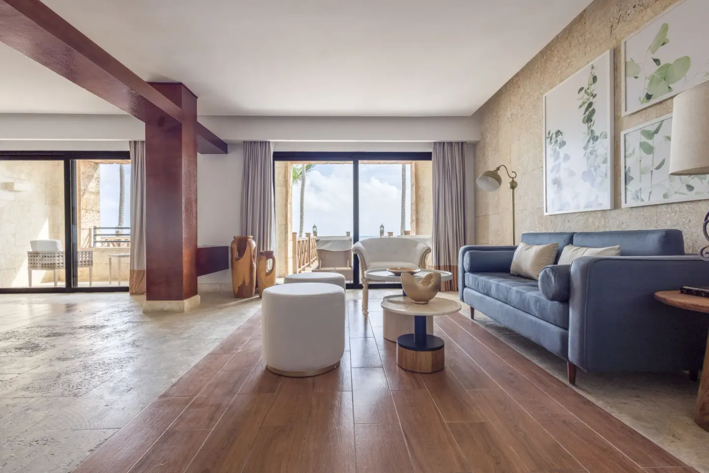 Junior Suite sitting room with sofa and balcony doors at Sanctuary Cap Cana, a Luxury Collection Resort.
