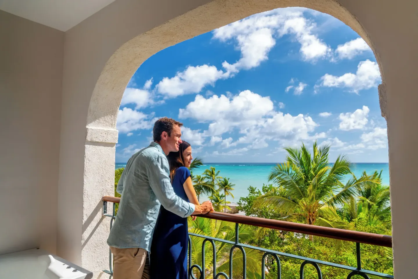 Couple on an ocean-view balcony at Sanctuary Cap Cana, a Luxury Collection Resort.