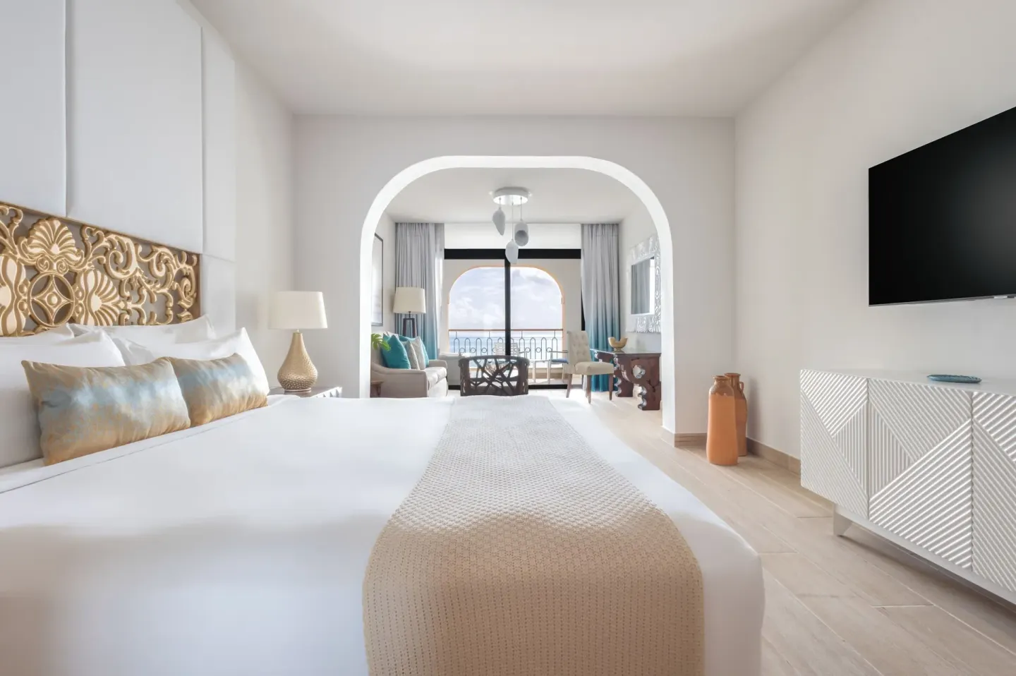 King bed and ocean-facing balcony in a junior suite at Sanctuary Cap Cana, a Luxury Collection Resort.