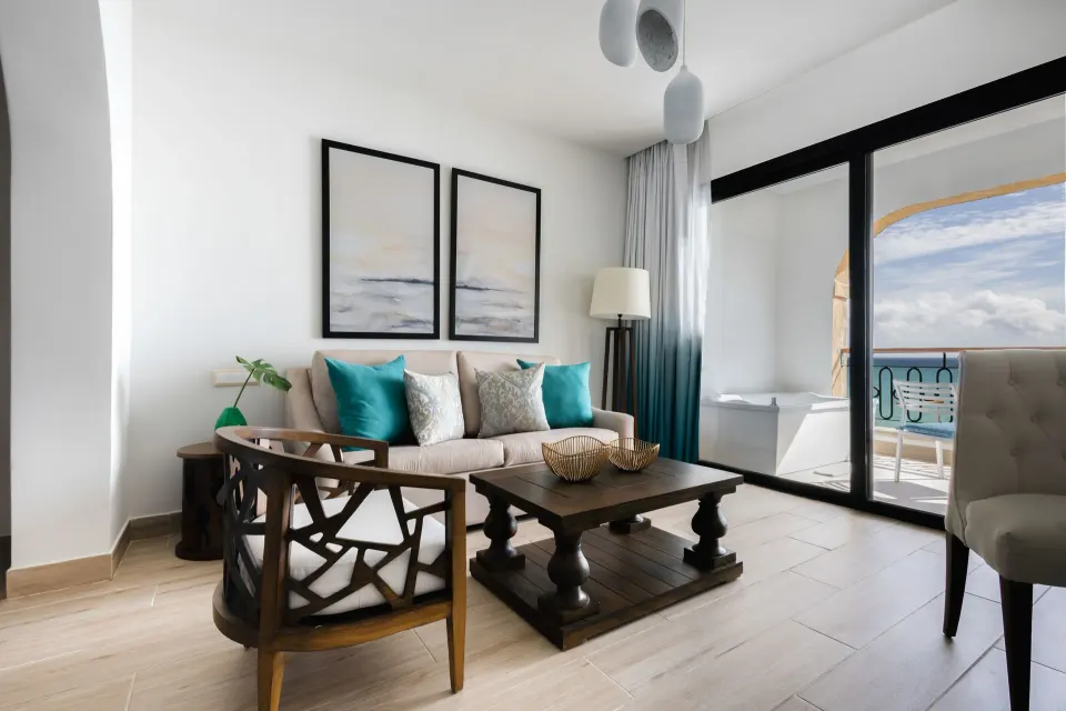 Ocean-view junior suite sitting area and balcony at Sanctuary Cap Cana, a Luxury Collection Resort.