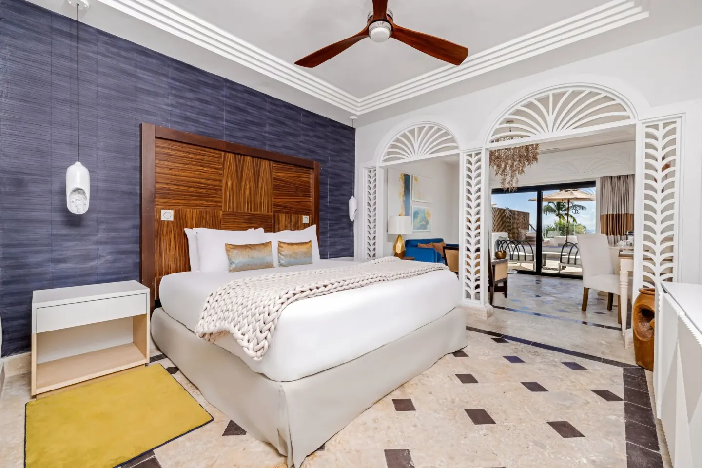 Junior Suite king bedroom at Sanctuary Cap Cana, a Luxury Collection Resort with blue accent wall and ocean-facing balcony be