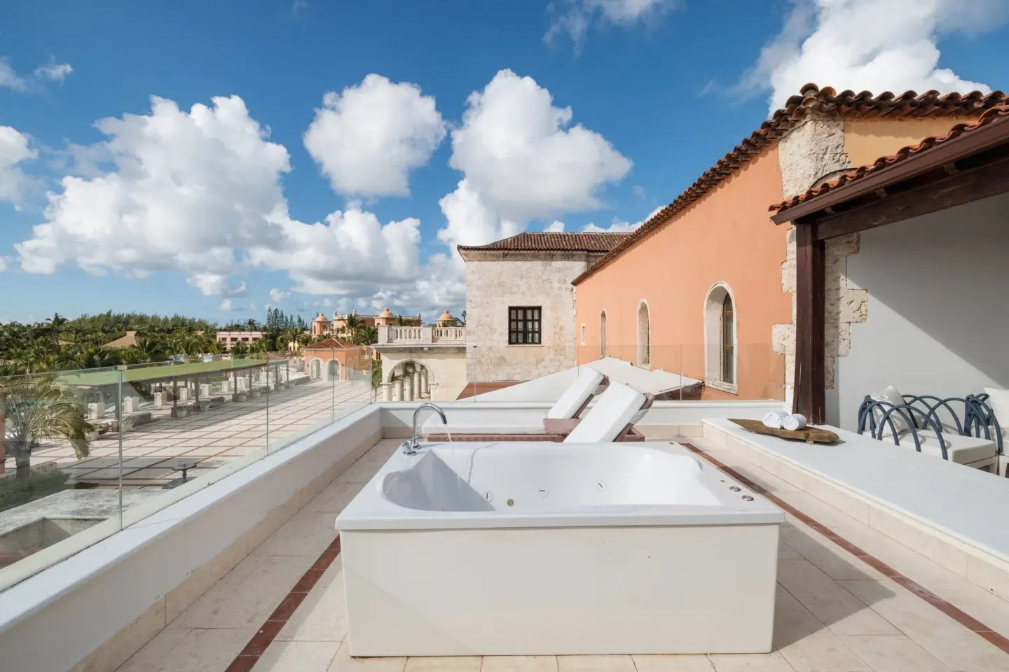 Junior Suite terrace at Sanctuary Cap Cana, a Luxury Collection Resort with outdoor whirlpool tub, loungers, and resort rooft