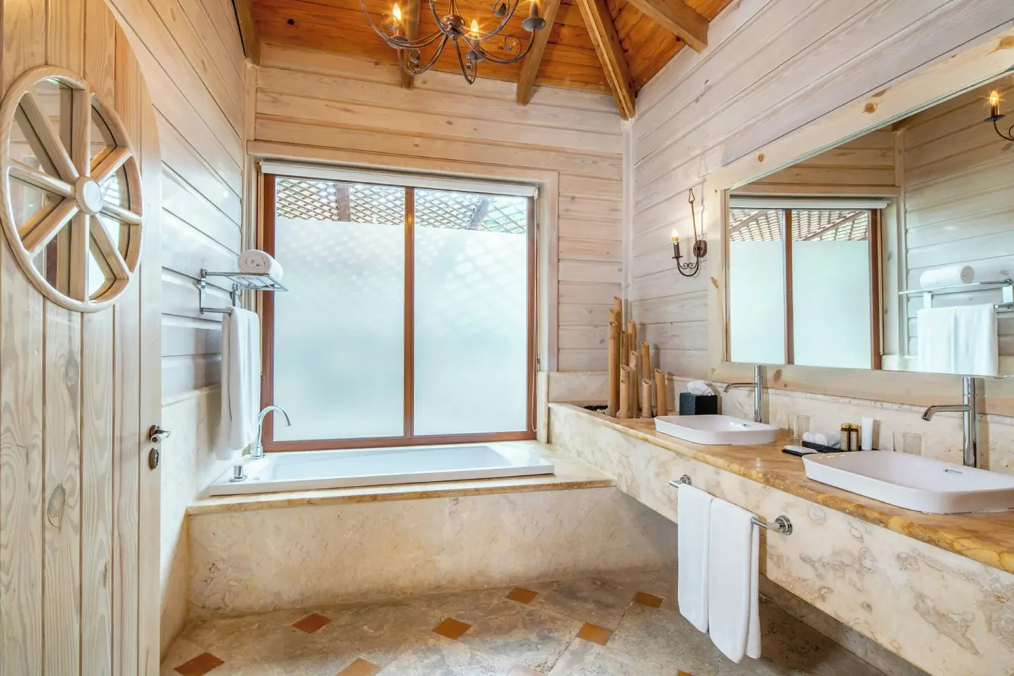 Oceanfront villa bathroom tub beneath frosted window at Sanctuary Cap Cana, a Luxury Collection Resort.