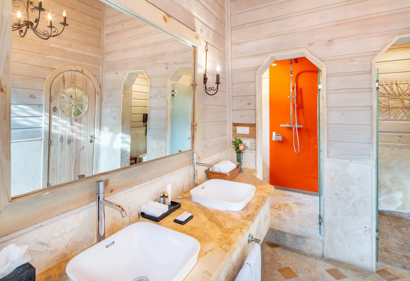 Oceanfront villa bathroom with twin sinks and orange shower at Sanctuary Cap Cana, a Luxury Collection Resort.