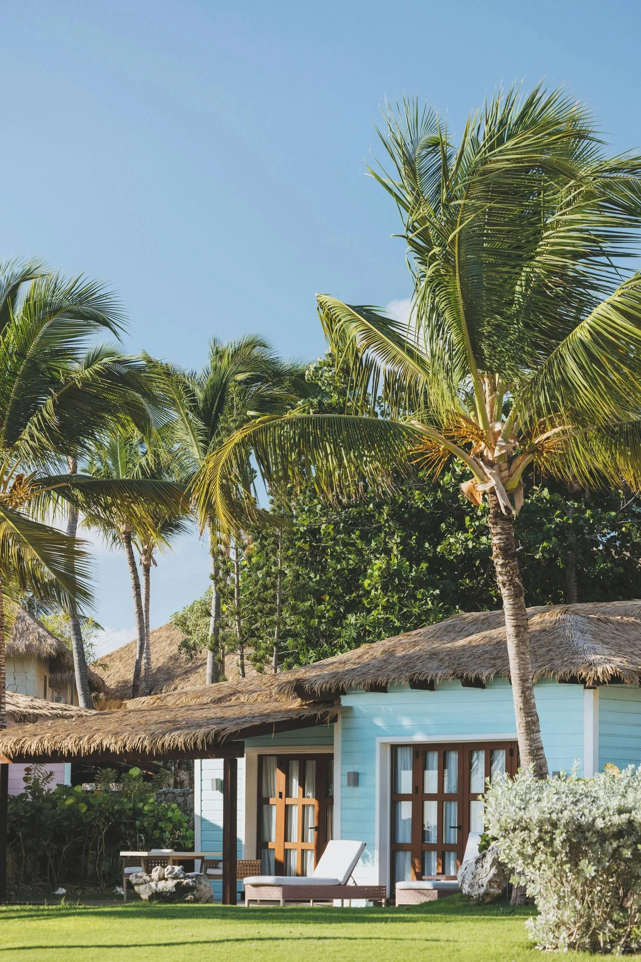 Oceanfront villa exterior with palm trees and terrace at Sanctuary Cap Cana, a Luxury Collection Resort.