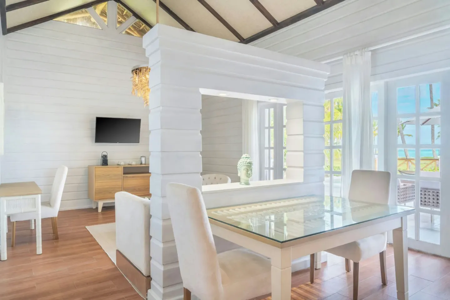 Villa Balcony living room with dining table and ocean-facing doors at Sanctuary Cap Cana, a Luxury Collection Resort.