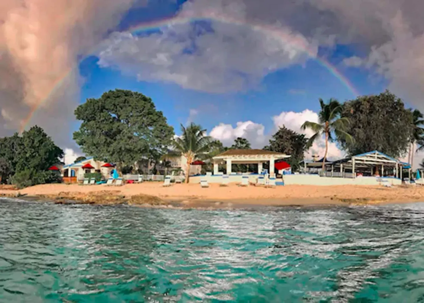 Beachfront resort view with rainbow over Sand Castle on the Beach.