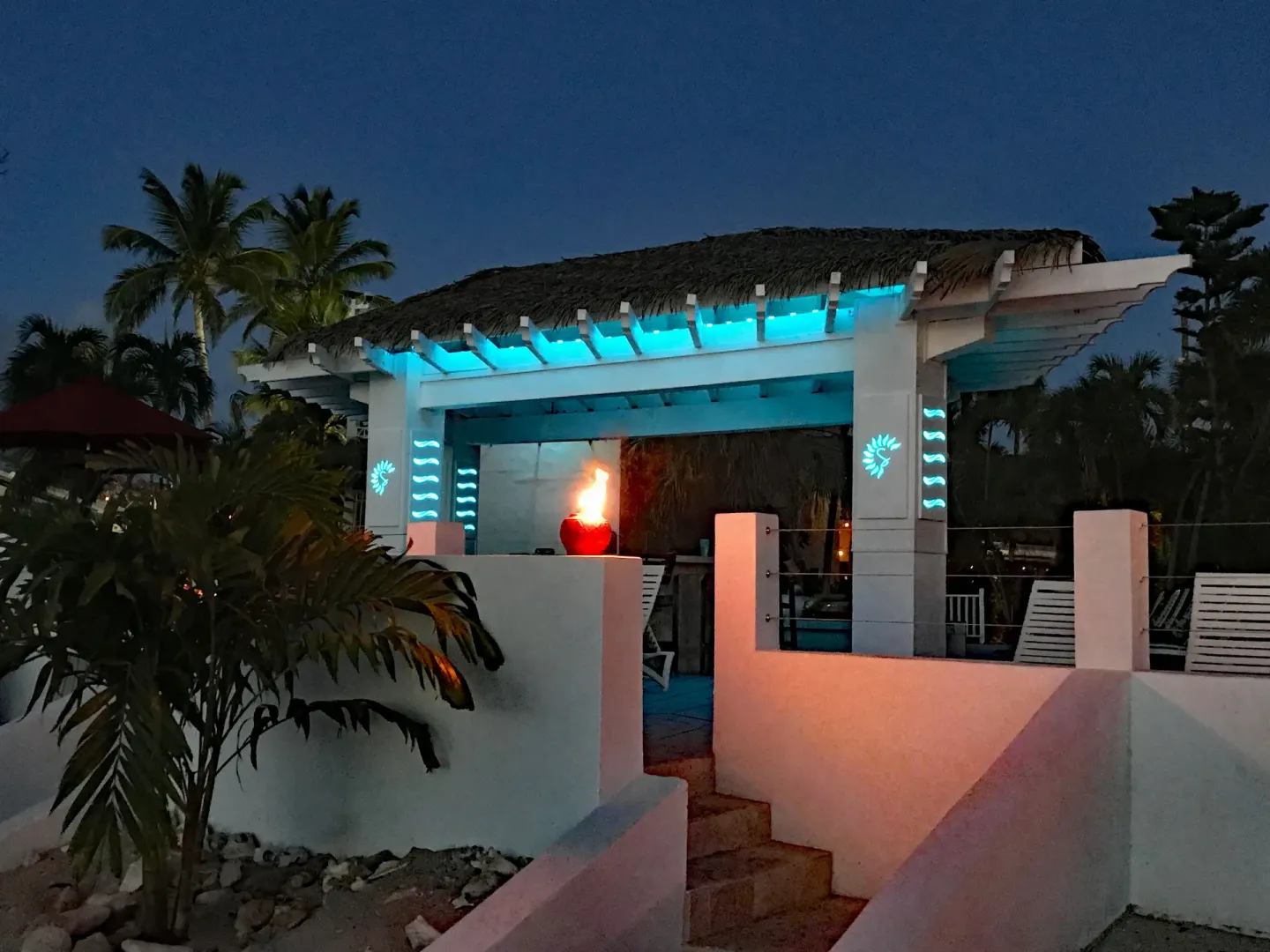 Nighttime poolside pavilion with turquoise lighting at Sand Castle on the Beach.