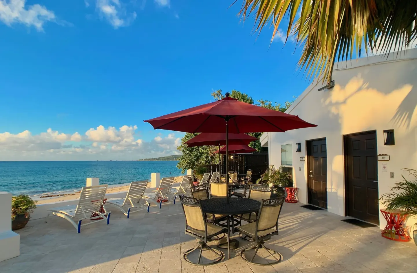 Oceanfront patio with tables, umbrellas, and lounge chairs at Sand Castle on the Beach.
