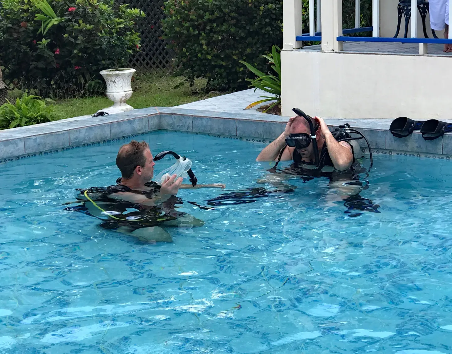 Two scuba divers practicing with masks and tanks in the pool at Sand Castle on the Beach.