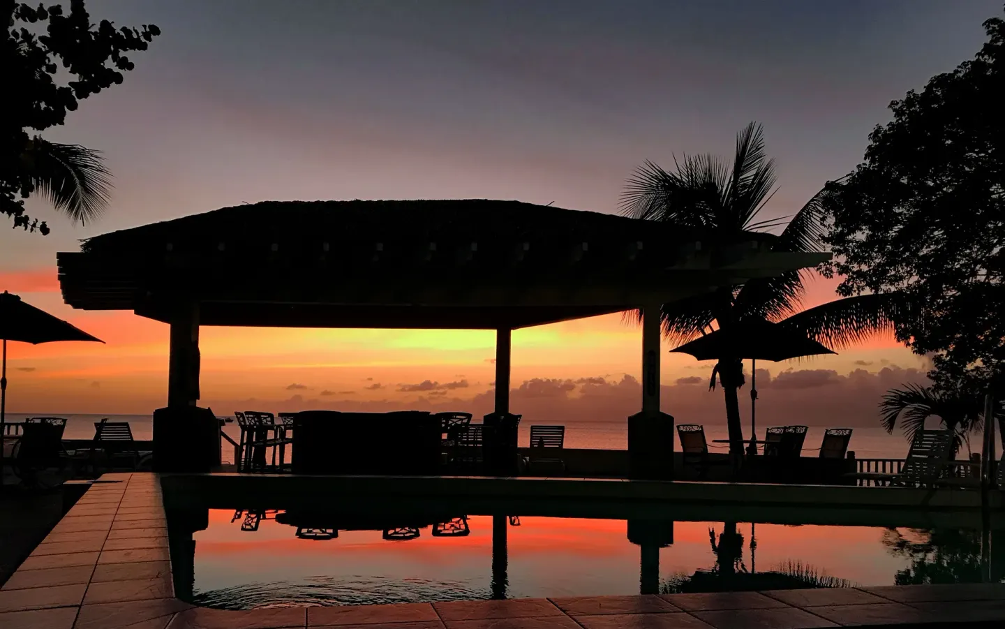Sunset reflected in the pool beside an oceanfront pavilion at Sand Castle on the Beach.