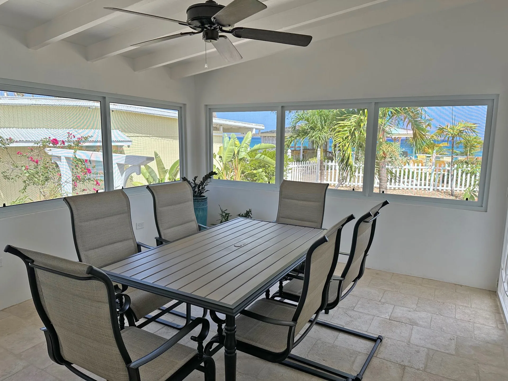 Enclosed dining area in the Dolphin Villa at Sand Castle on the Beach with table and garden views.