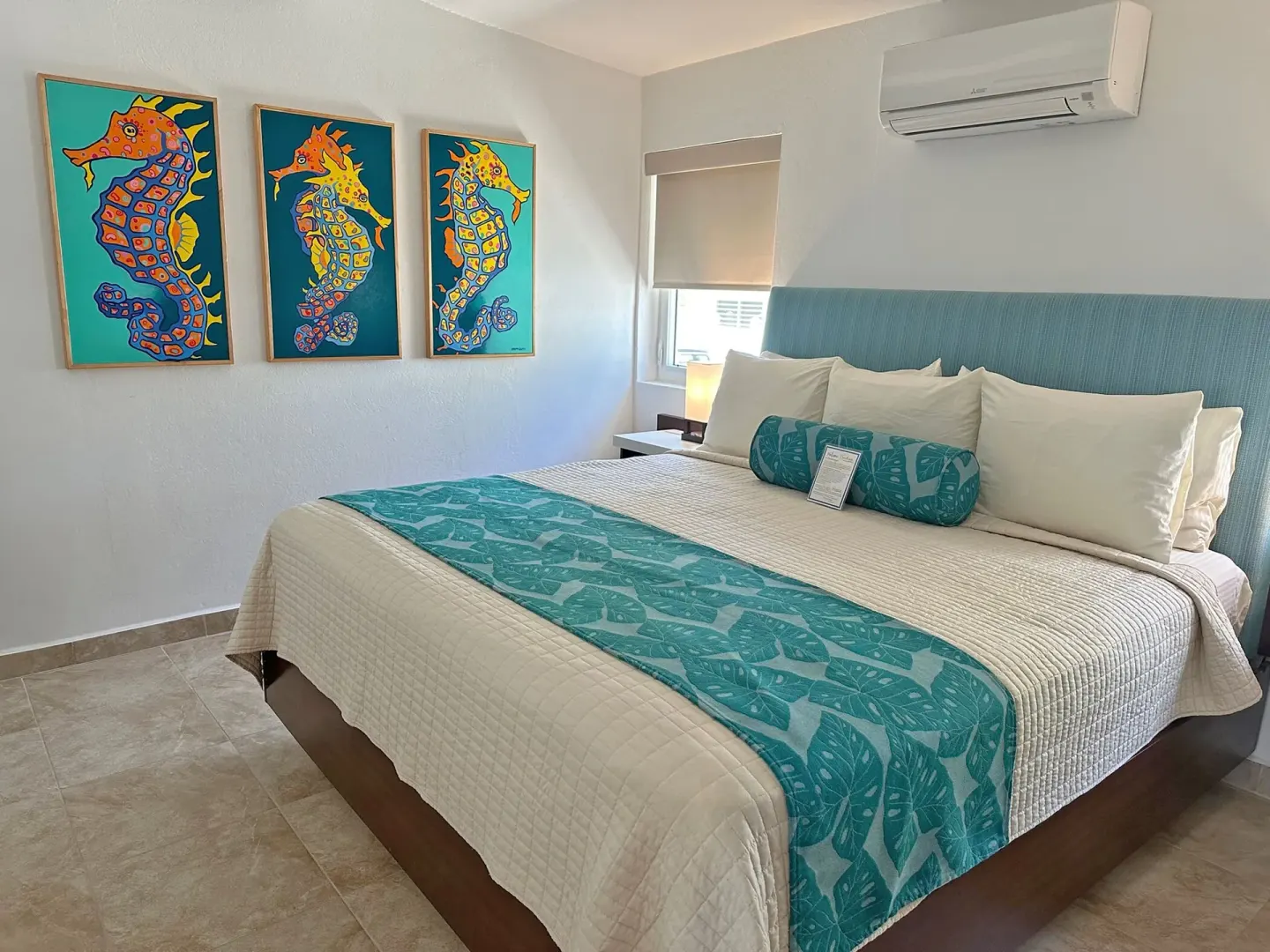 Dolphin Villa king bedroom at Sand Castle on the Beach with seahorse art and turquoise bedding.