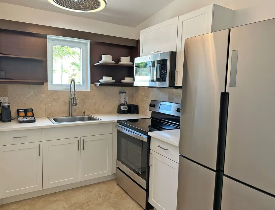 Dolphin Villa kitchen at Sand Castle on the Beach with stainless appliances, sink, and open shelves.