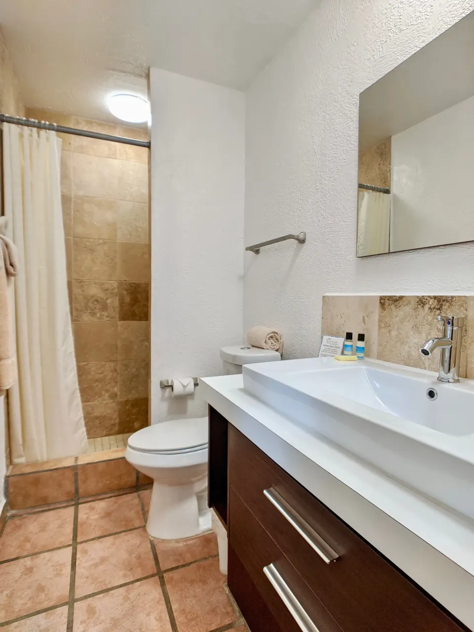 Standard Room bathroom with shower, toilet, and vanity at Sand Castle on the Beach.