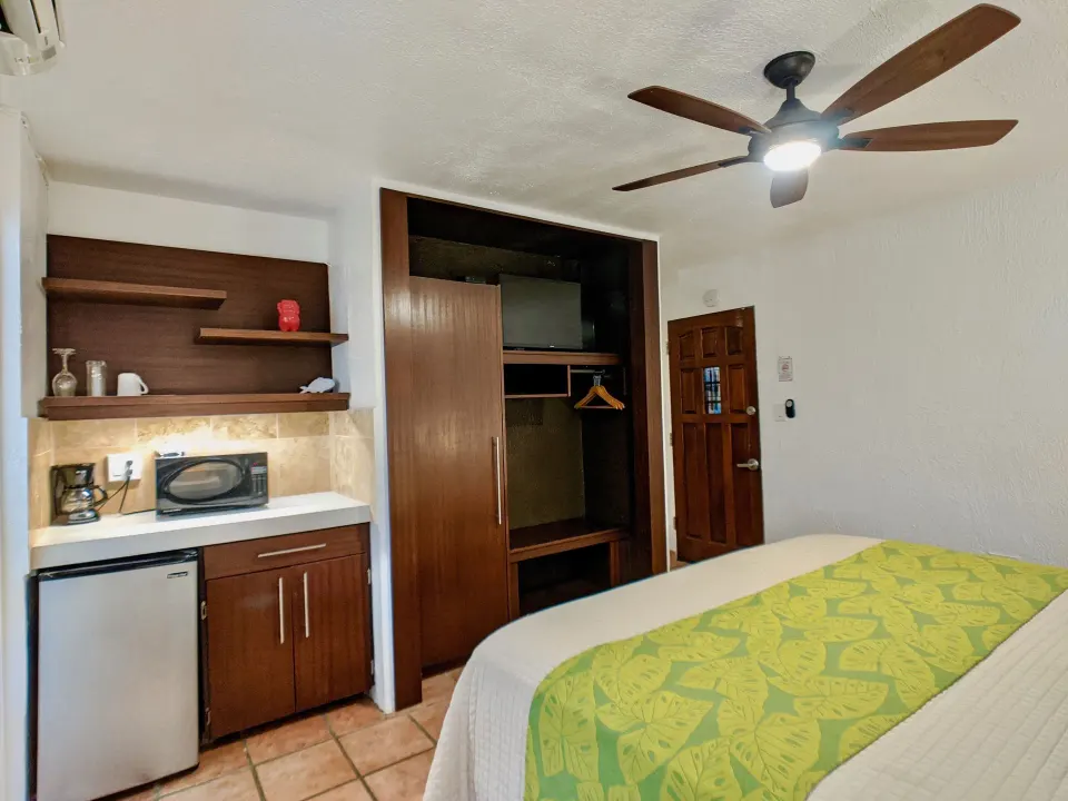 Standard Room king bed with kitchenette and open closet at Sand Castle on the Beach.
