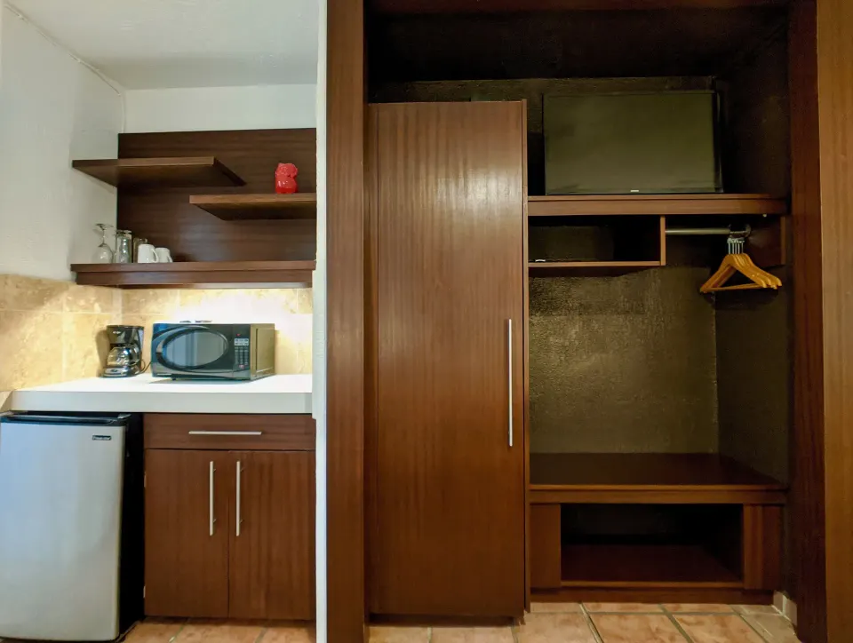Standard Room kitchenette and open wardrobe at Sand Castle on the Beach.