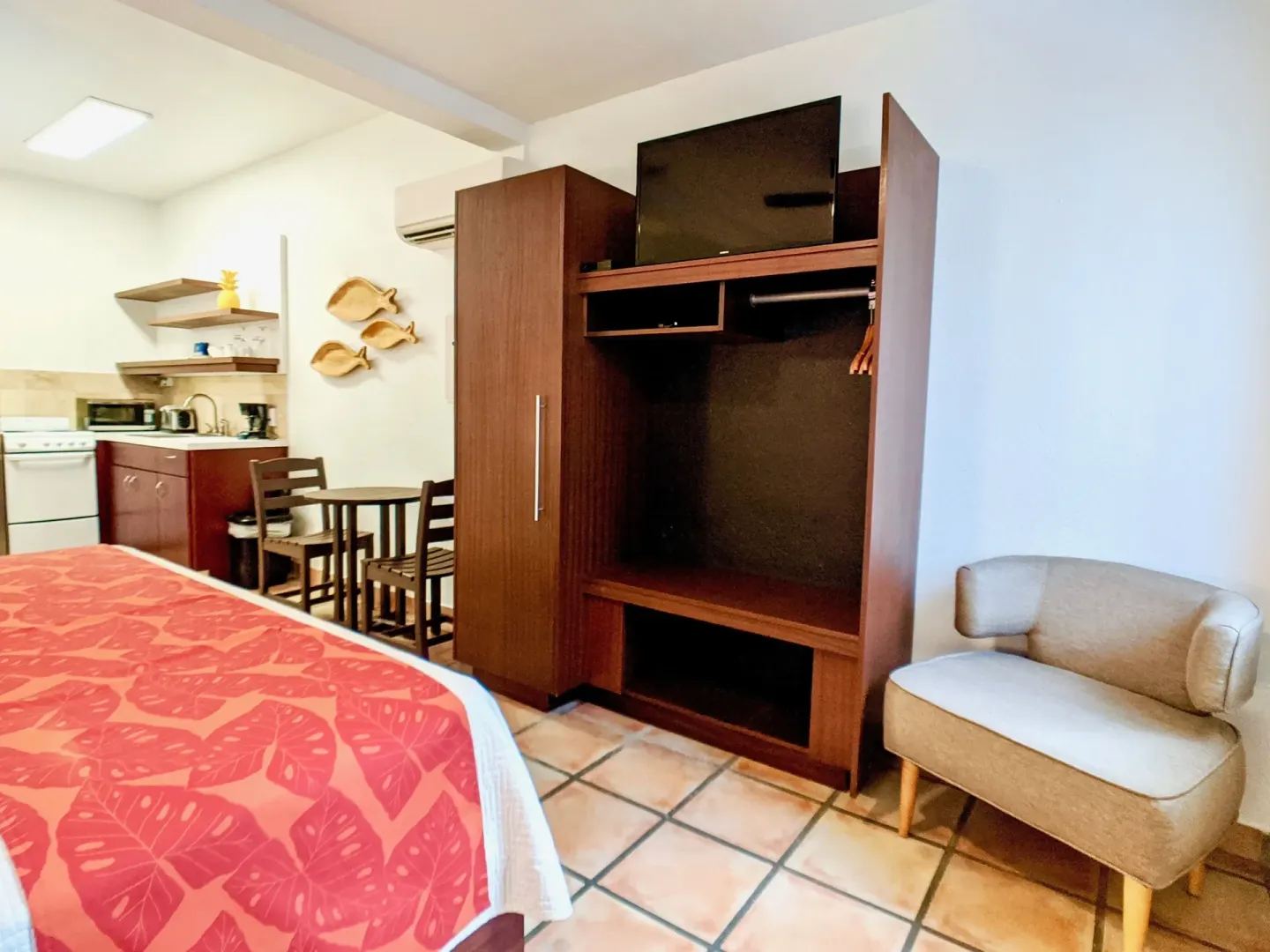 Studio Garden View room with bed, kitchenette, wardrobe, TV, and chair at Sand Castle on the Beach.