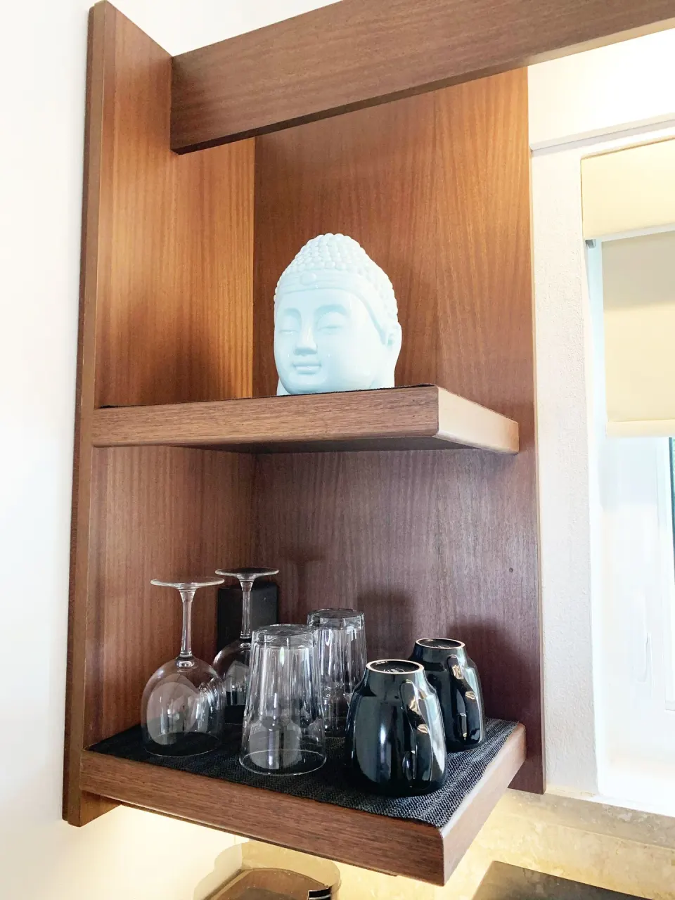 Studio drinkware shelf with glasses, mugs, and decor at Sand Castle on the Beach.