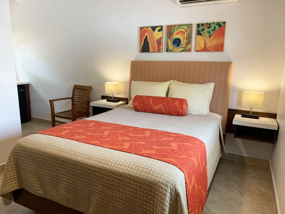 Studio king bed with coral accents and wall art at Sand Castle on the Beach.
