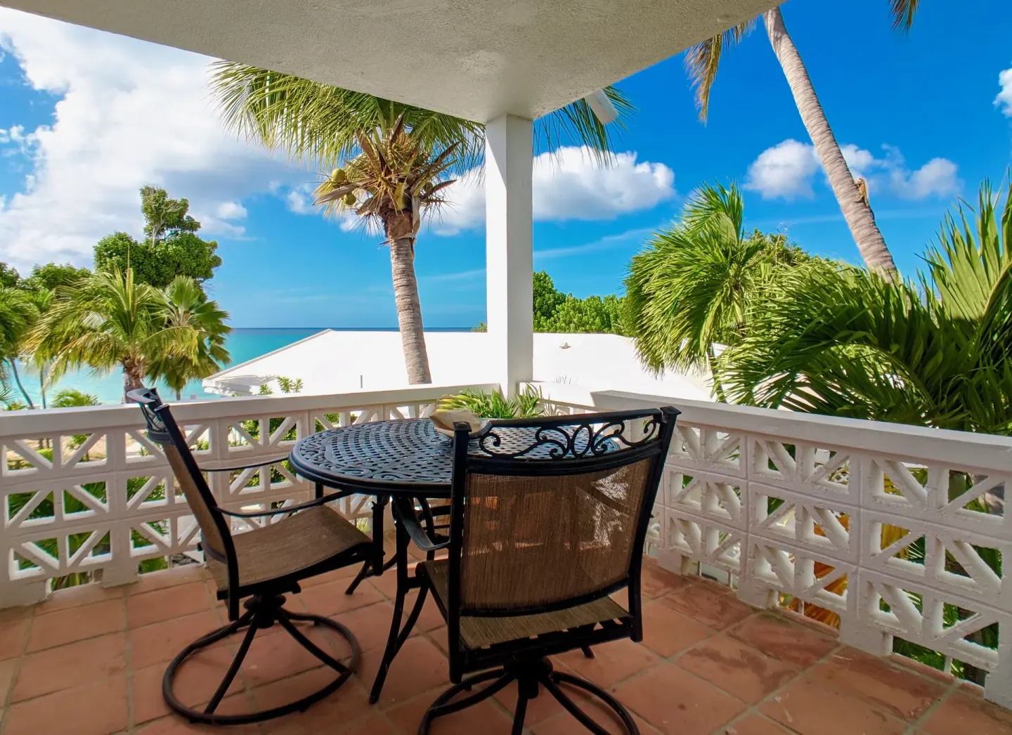 Furnished balcony with palm trees and sea view at Sand Castle on the Beach.