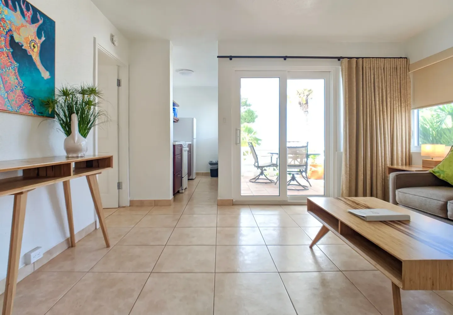 Living area of a sea-view suite with sofa bed and balcony doors at Sand Castle on the Beach.