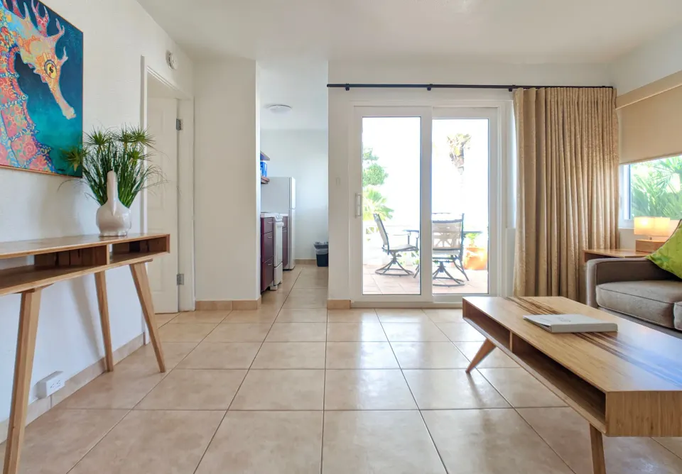 Living area of a sea-view suite with sofa bed and balcony doors at Sand Castle on the Beach.