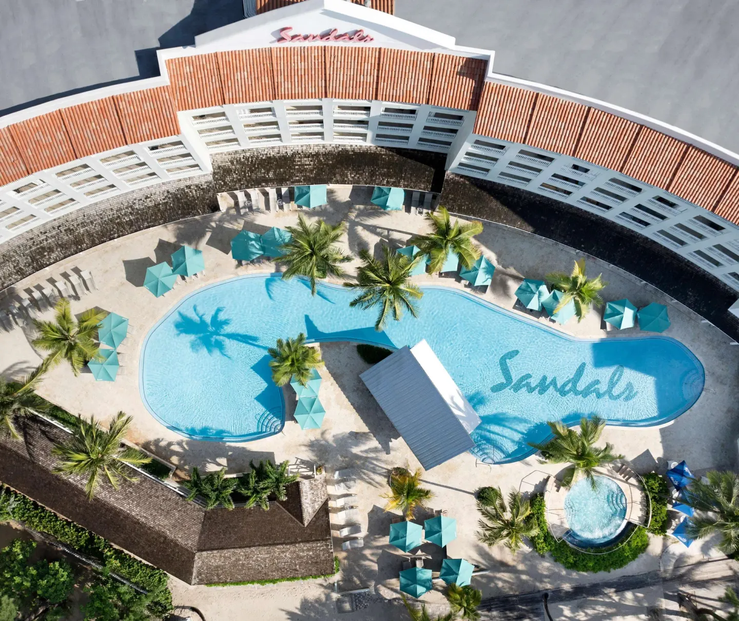 Aerial daytime view of the main pool and loungers at Sandals Barbados.