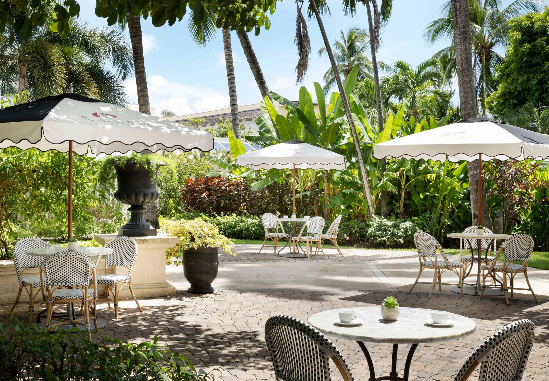 Garden patio with umbrella tables and tropical landscaping at Sandals Barbados.