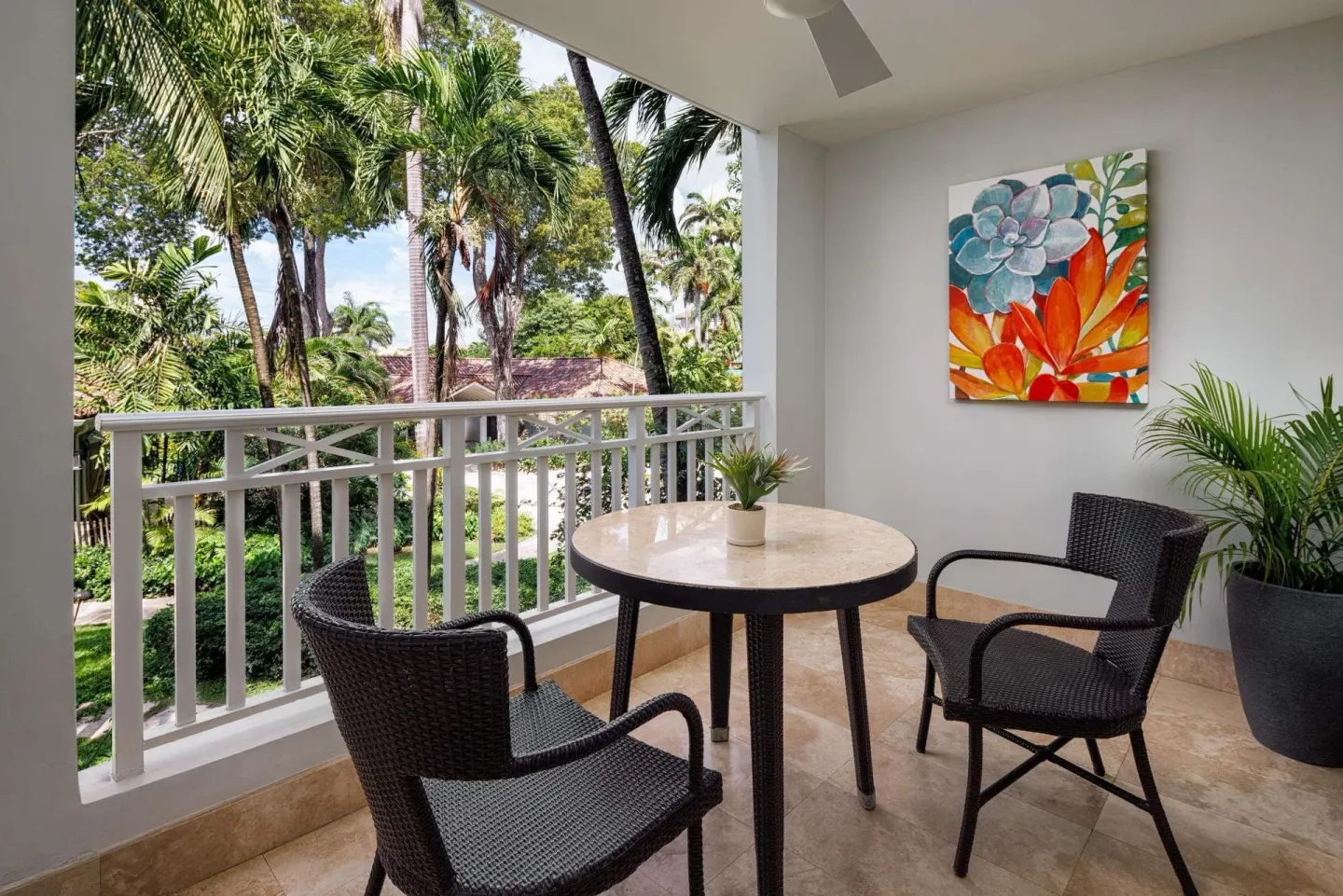 Furnished balcony with garden and palm views at Sandals Barbados.