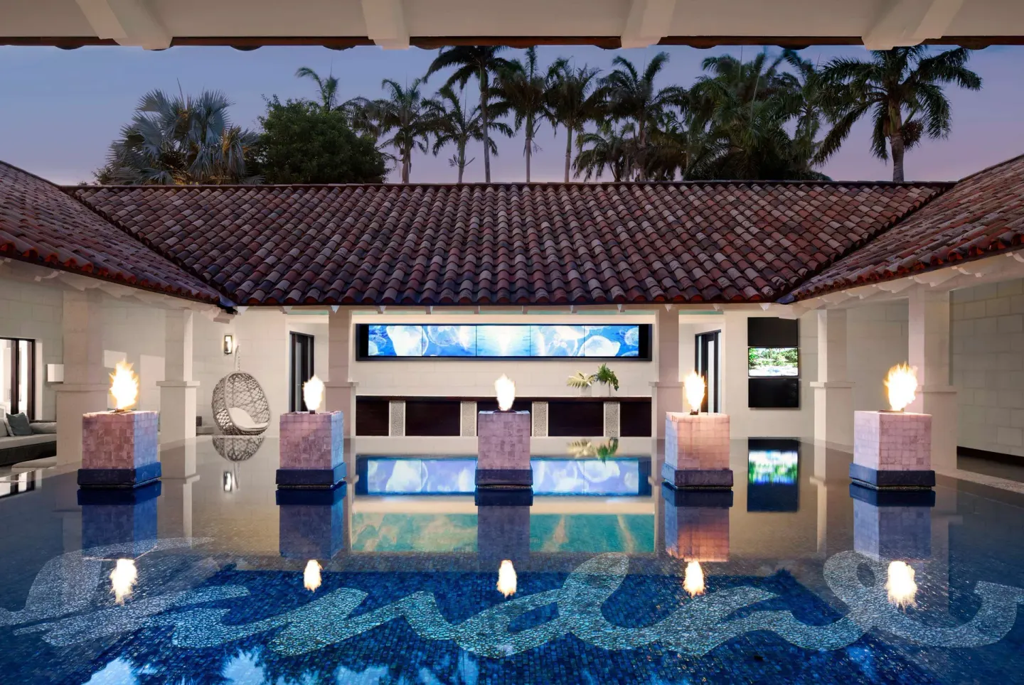 Reflecting pool with fire features in a covered lobby area at Sandals Barbados.