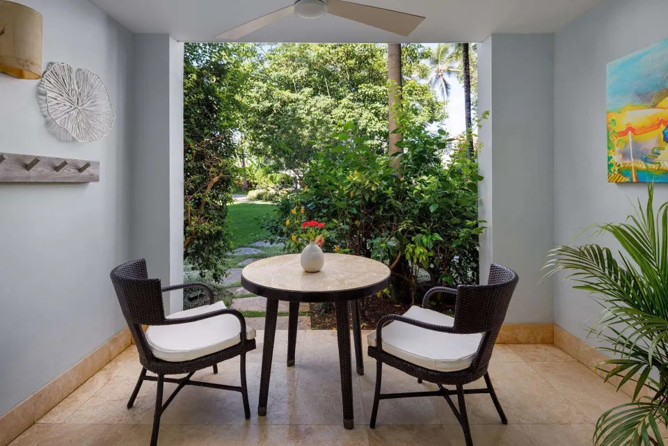 Covered garden patio with table and two chairs for a Luxury Room at Sandals Barbados.