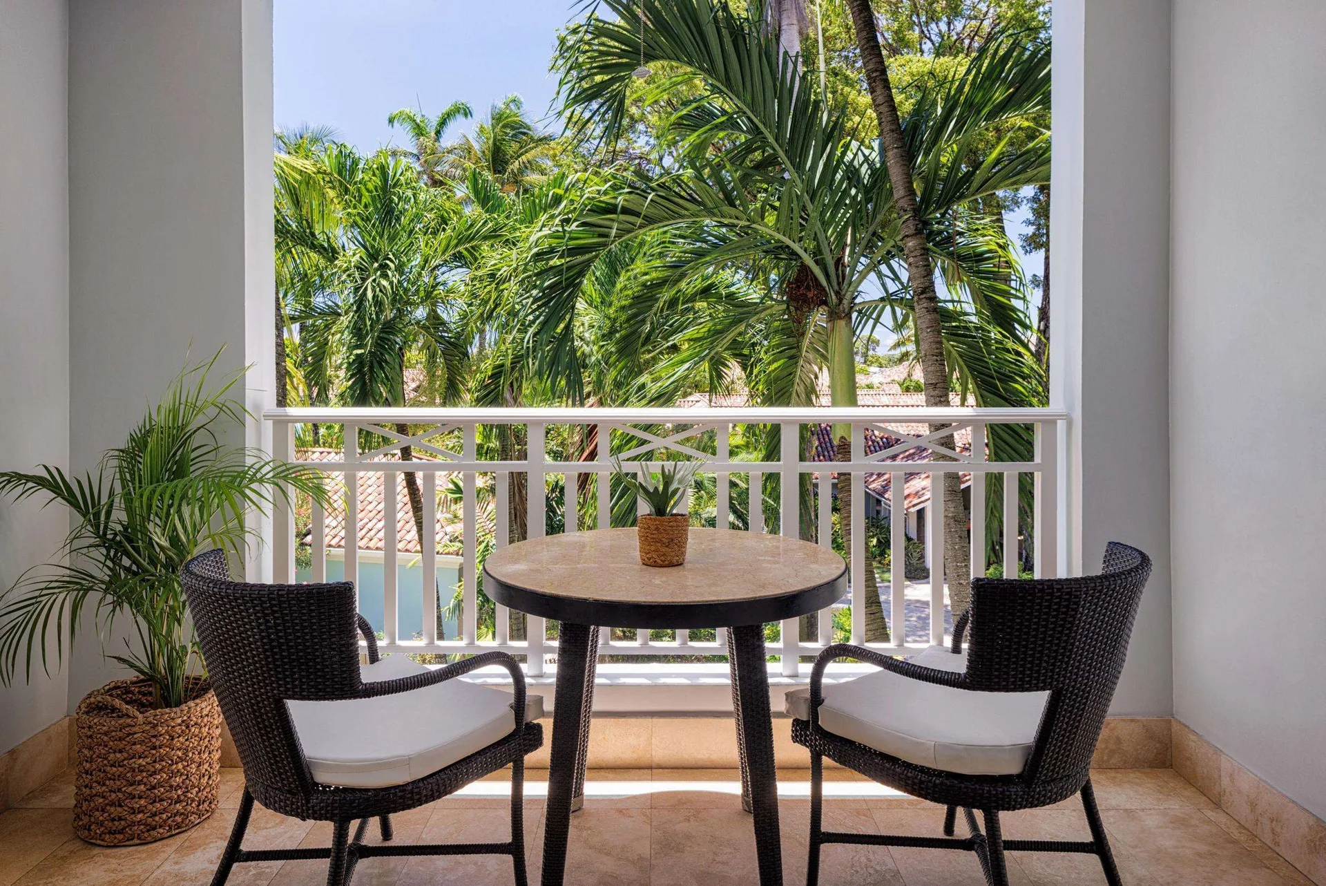 Private balcony with two chairs and a garden view at Sandals Barbados.