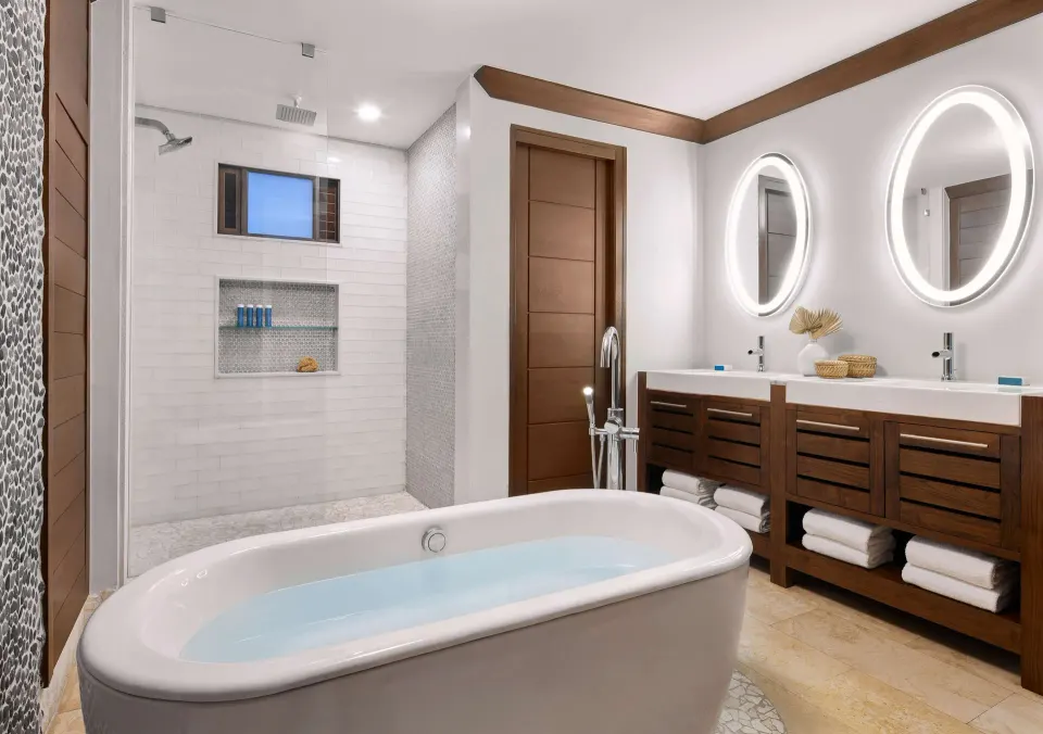 Bathroom with freestanding tub, walk-in shower, and double vanity at Sandals Barbados.
