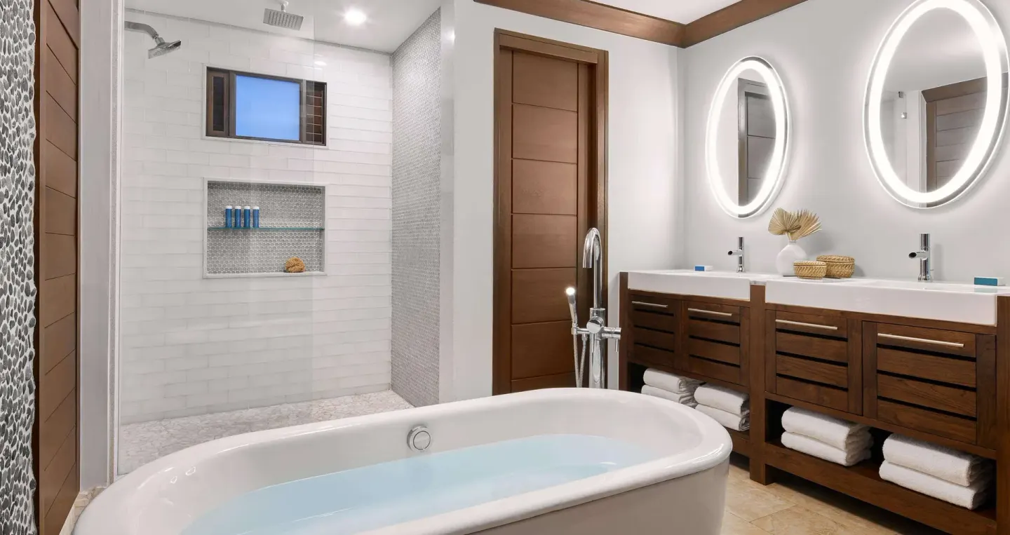 Modern bathroom with tub, shower, and twin sinks at Sandals Barbados.