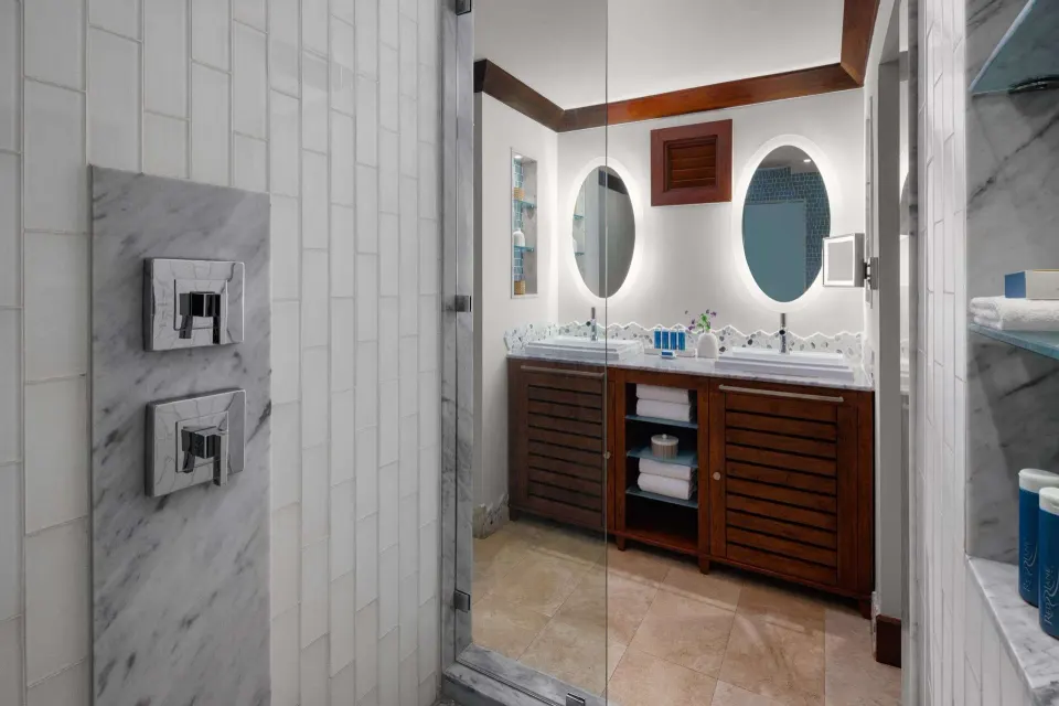 Bathroom with glass shower and double vanity in a luxury room at Sandals Barbados.