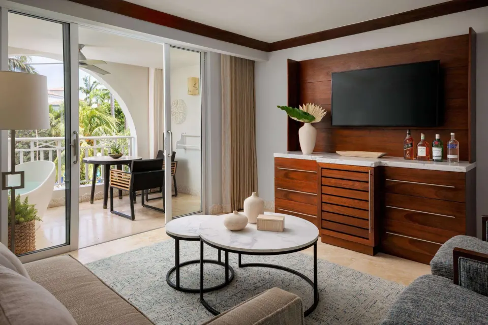 Living area with balcony access in a garden view luxury suite at Sandals Barbados.