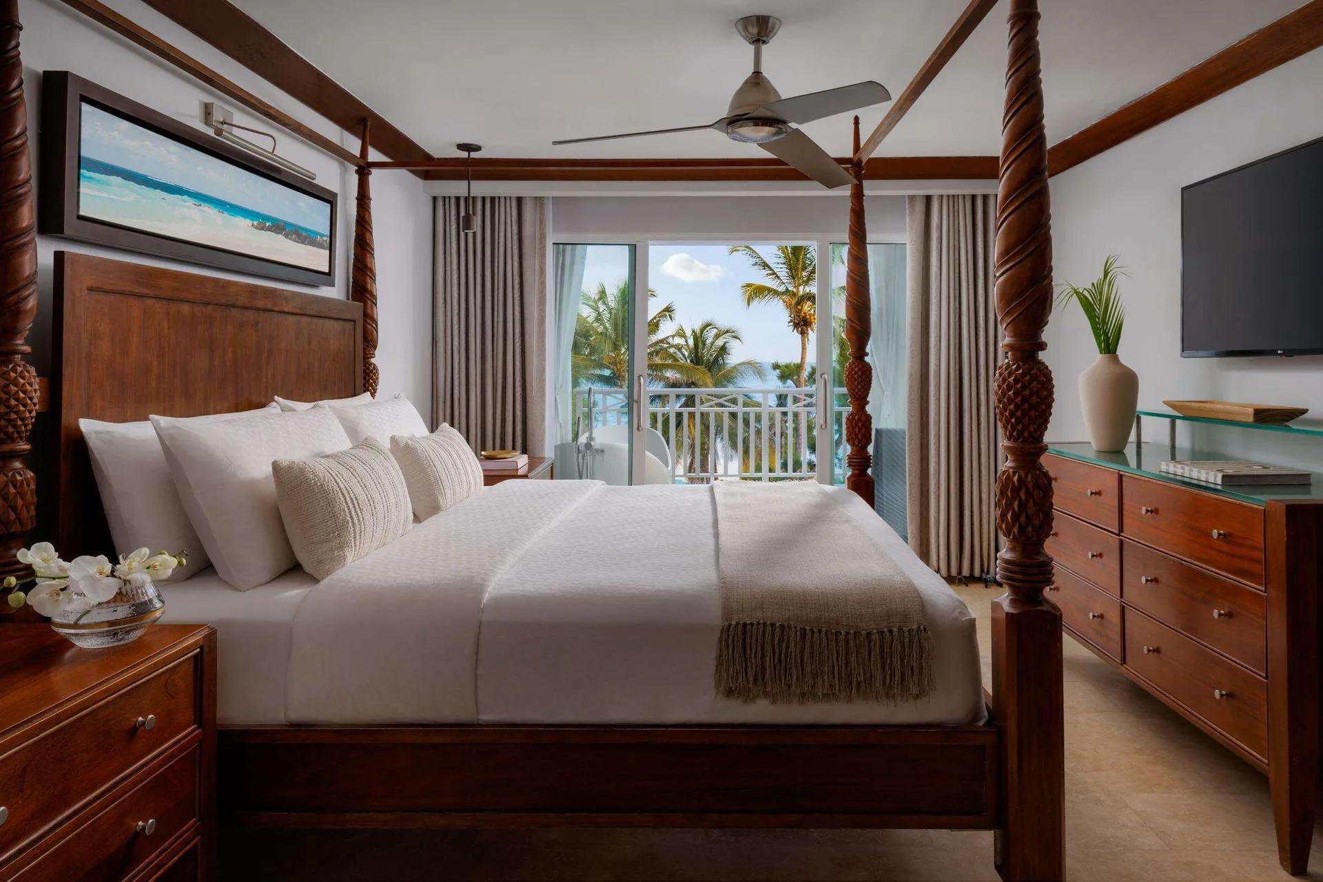 One Bedroom Ocean View Beachfront Butler Suite at Sandals Barbados with four-poster king bed, elegant décor, and oceanfront balcony views over Maxwell Beach.
