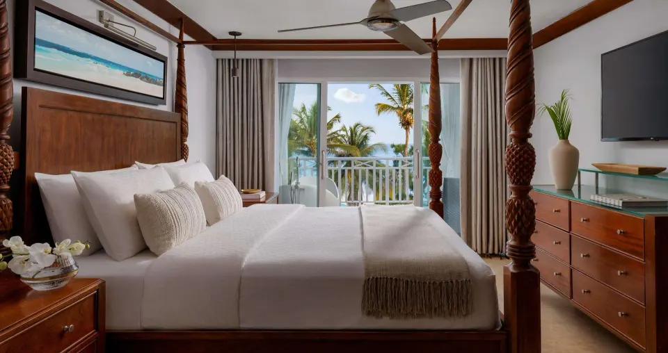 Ocean view suite bedroom with four-poster bed and balcony at Sandals Barbados.